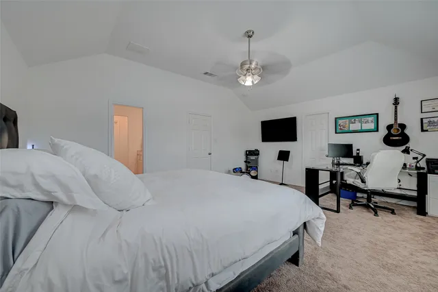a bedroom with a large bed and a tv
