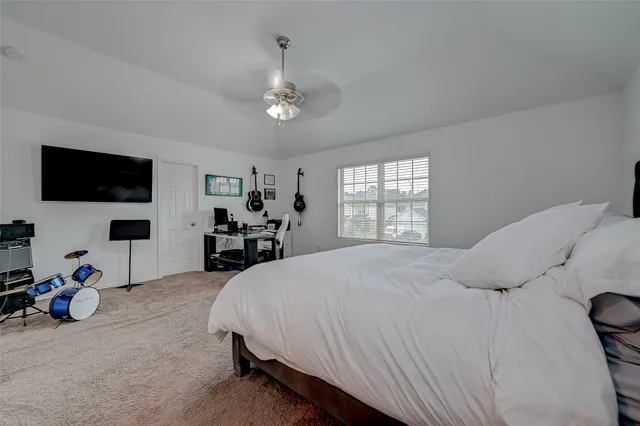 a bedroom with a bed and a flat tv screen on the dresser