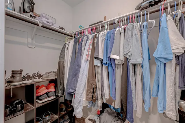 a view of walk in closet with clothes and shoes
