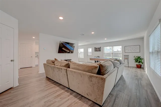 a living room with furniture and a wooden floor