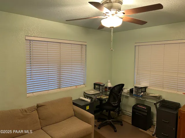 a view of a workspace with furniture and a window