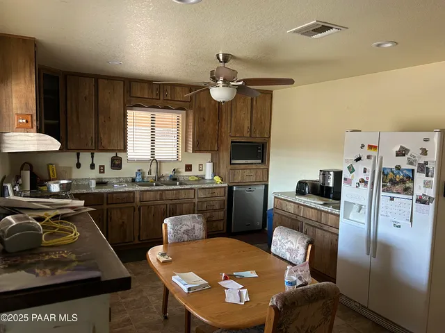 a kitchen with granite countertop a sink stove and refrigerator