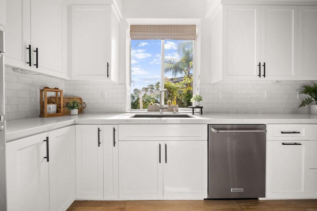 7100 Surfbird Circle Carlsbad, CA 92011 - Photo 13 of 65 a kitchen with white cabinets and a window