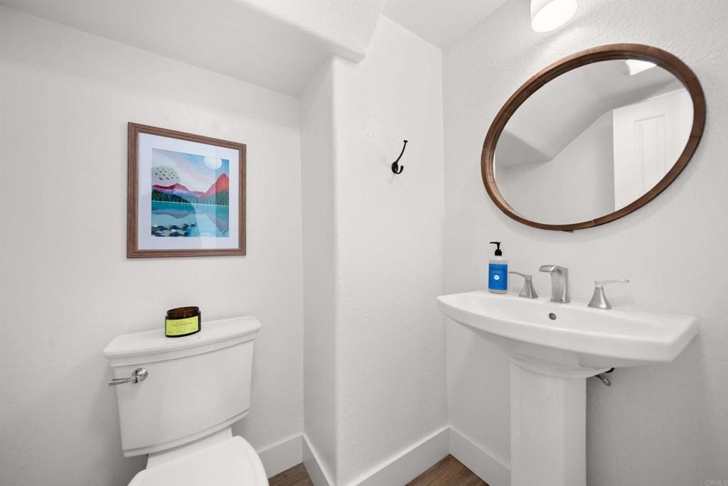 7100 Surfbird Circle Carlsbad, CA 92011 - Photo 26 of 65 a bathroom with a toilet a sink and mirror