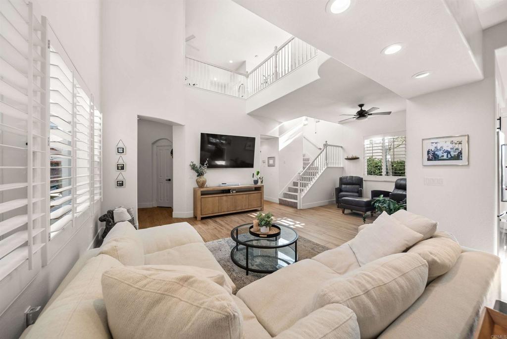 7100 Surfbird Circle Carlsbad, CA 92011 - Photo 7 of 65 a living room with furniture a large window and a flat screen tv