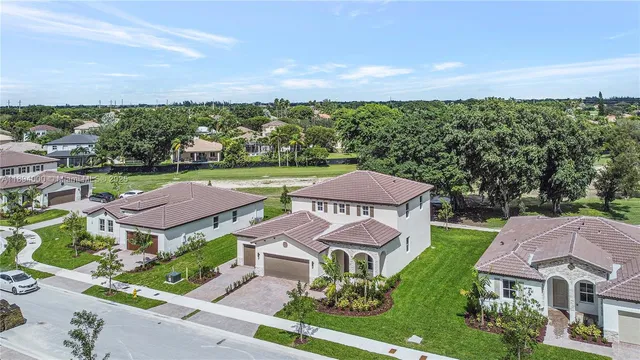 an aerial view of residential houses with outdoor space and trees