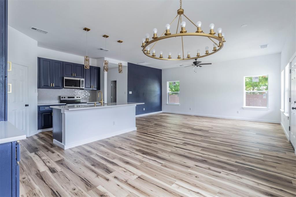 Kitchen featuring appliances with stainless steel finishes, a chandelier, blue cabinets, and a ceiling fan