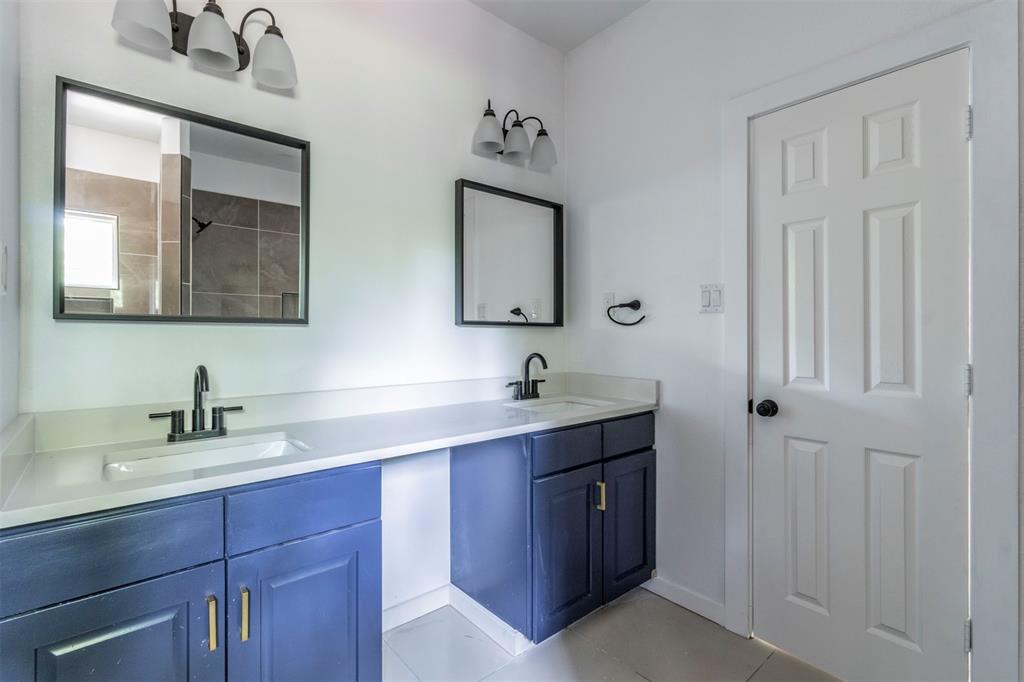 1014 Trinity Street Cleburne, TX 76031 - Photo 10 of 34 Full bath with double vanity, tile patterned floors, and baseboards
