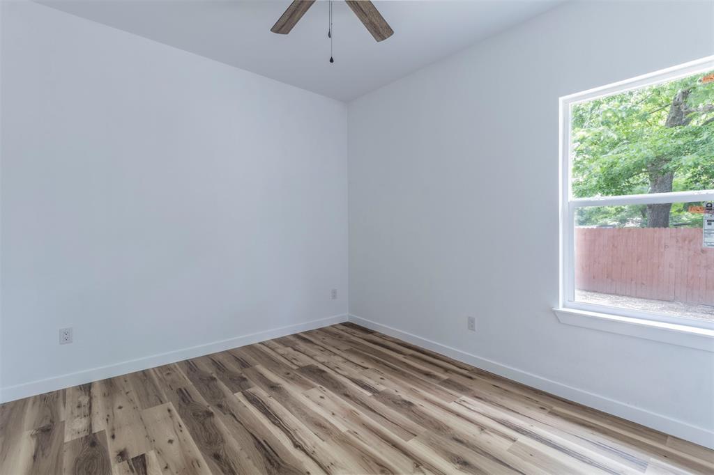 1014 Trinity Street Cleburne, TX 76031 - Photo 17 of 34 Spare room featuring a ceiling fan, wood finished floors, and baseboards