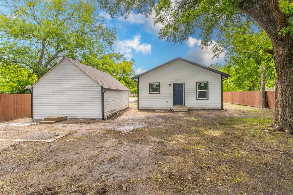 1014 Trinity Street Cleburne, TX 76031 - Photo 28 of 34 Back of property featuring entry steps and a fenced backyard