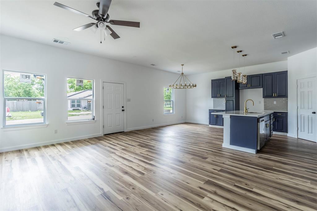 1014 Trinity Street Cleburne, TX 76031 - Photo 34 of 34 Kitchen with open floor plan, a chandelier, light countertops, a sink, and wood finished floors