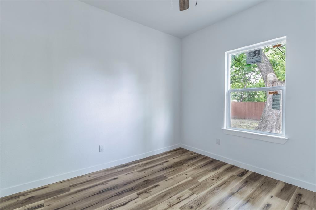 1014 Trinity Street Cleburne, TX 76031 - Photo 7 of 34 Unfurnished room with light wood-style floors, baseboards, and a ceiling fan