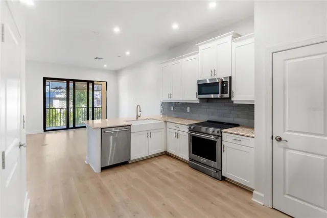 a kitchen with granite countertop white cabinets and stainless steel appliances