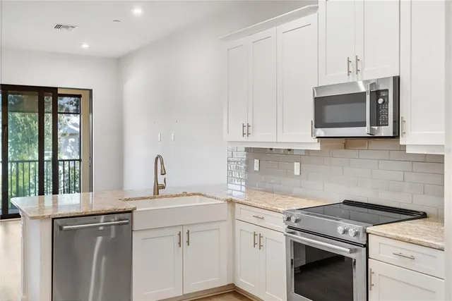 a kitchen with stainless steel appliances granite countertop white cabinets and a granite counter tops