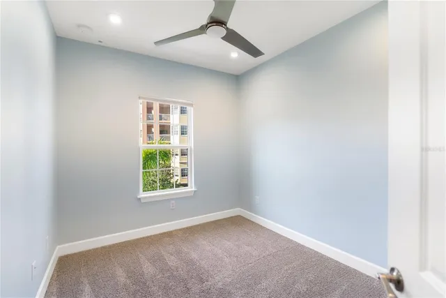 an empty room with a window and a fan