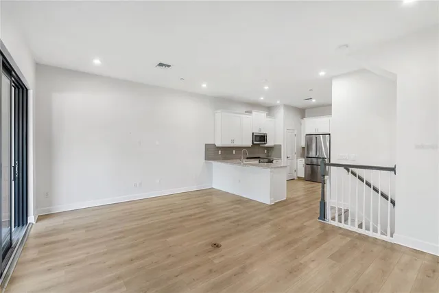 a kitchen with white cabinets and stainless steel appliances