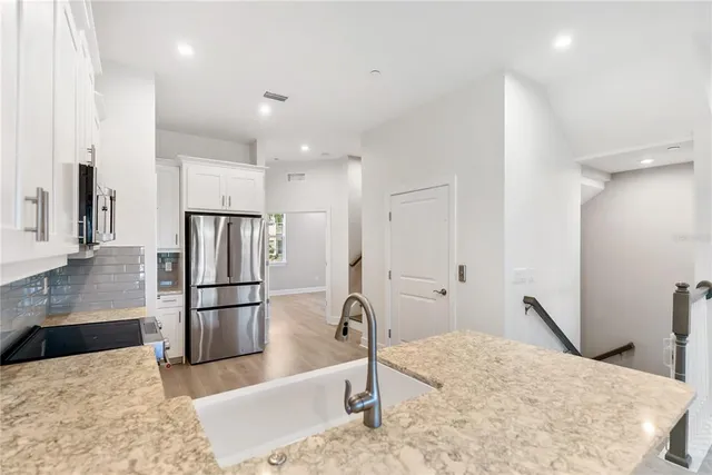 a kitchen with kitchen island a refrigerator and a sink