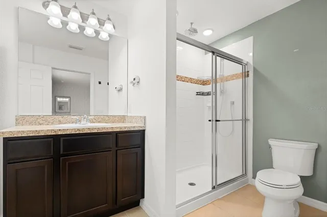 a bathroom with a sink vanity mirror and toilet