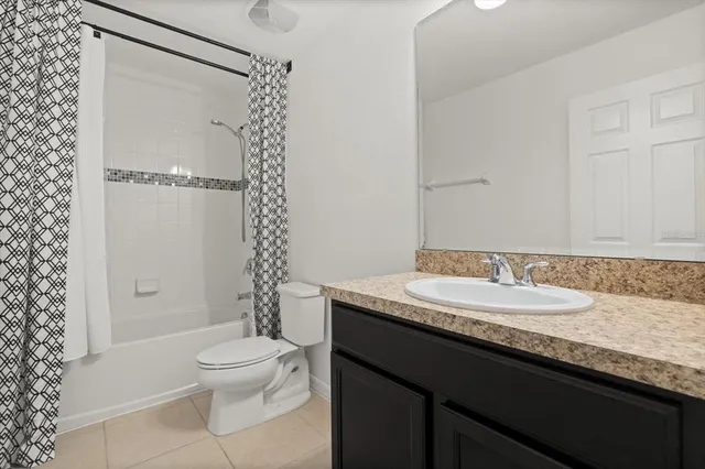 a bathroom with a granite countertop sink toilet mirror and shower