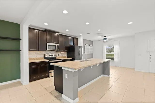 a large kitchen with stainless steel appliances granite countertop a large counter top and a stove top oven