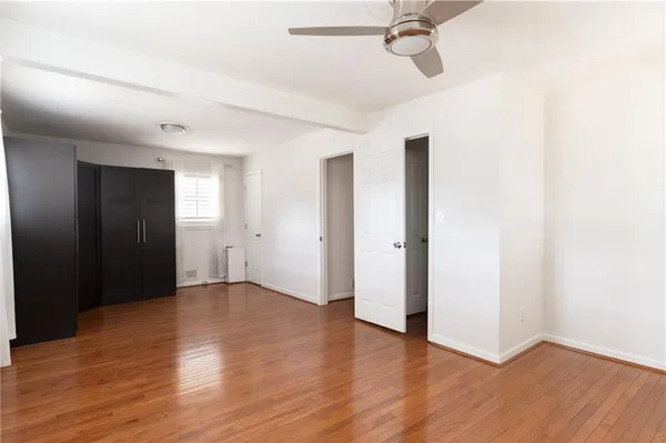 a view of an empty room with wooden floor