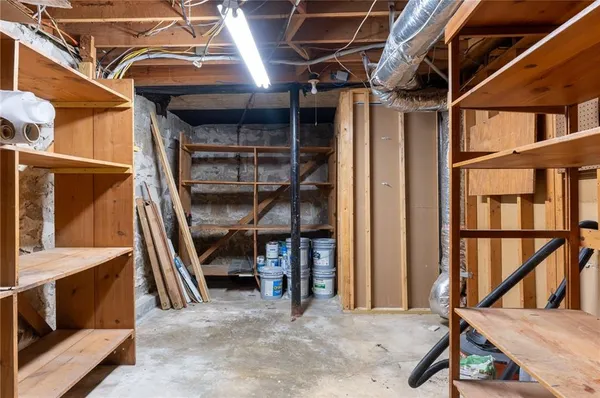 a view of an empty room with wooden roof and stairs