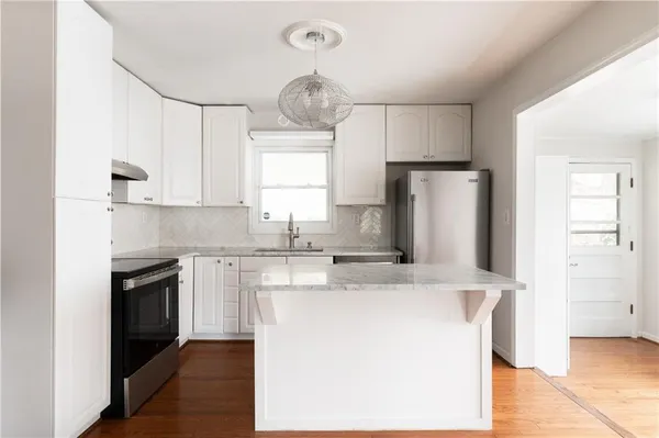 a kitchen with kitchen island a sink stainless steel appliances and window