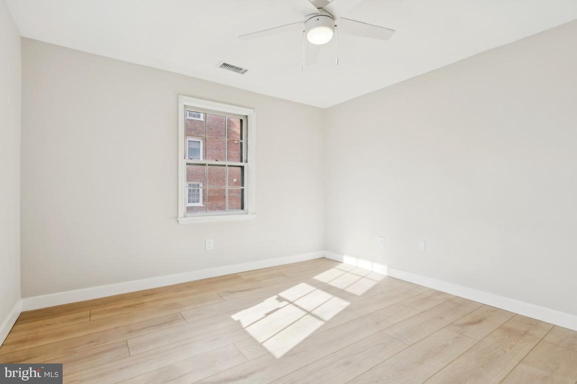 2037 38th Street Southeast, Unit 301 Washington, DC 20020 - Photo 14 of 15 an empty room with wooden floor fan and windows