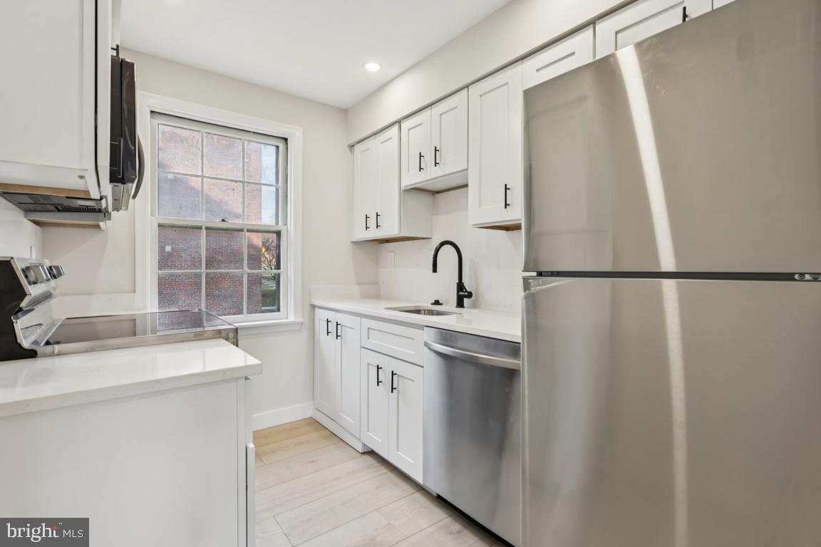 2037 38th Street Southeast, Unit 301 Washington, DC 20020 - Photo 2 of 15 a kitchen with stainless steel appliances granite countertop a sink stove and refrigerator