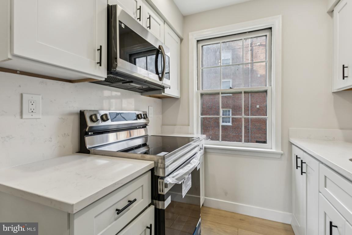 2037 38th Street Southeast, Unit 301 Washington, DC 20020 - Photo 4 of 15 a kitchen with stainless steel appliances a stove microwave and cabinets