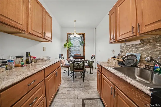 a kitchen with granite countertop a sink stove and cabinets