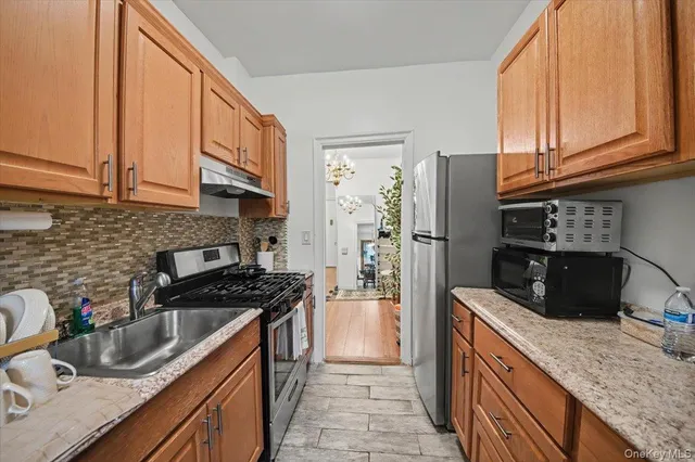a kitchen with stainless steel appliances granite countertop a sink stove and refrigerator