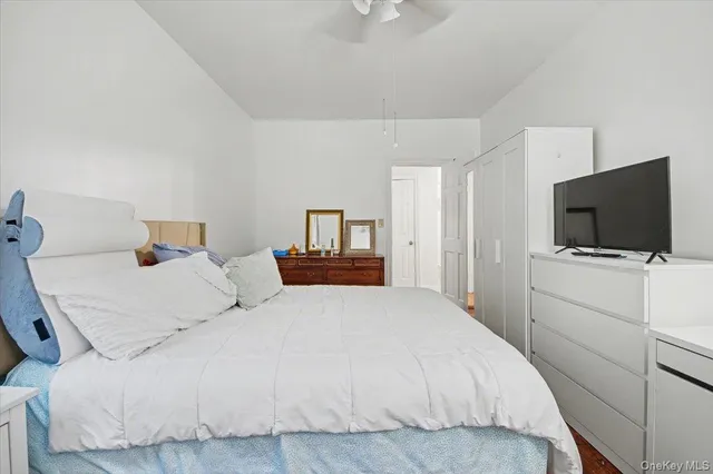 a bedroom with a bed and a flat tv screen on wall