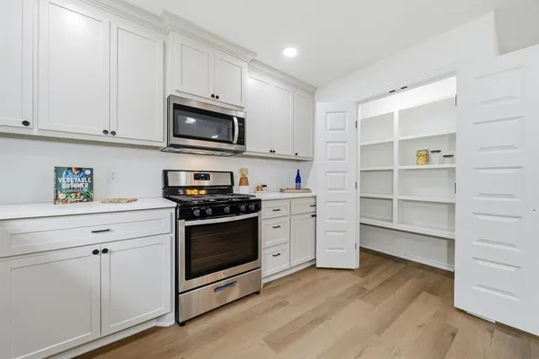 a kitchen with stainless steel appliances granite countertop a stove microwave and sink