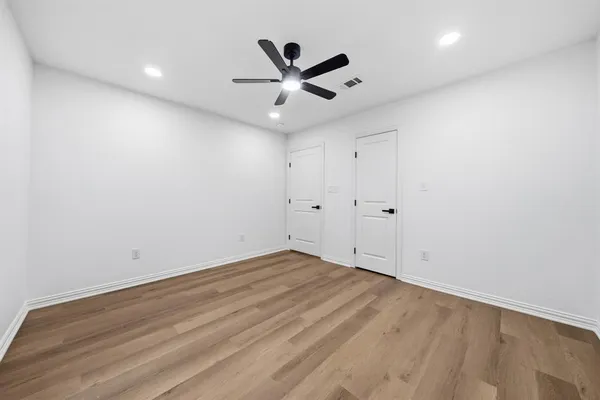 an empty room with ceiling fan and window
