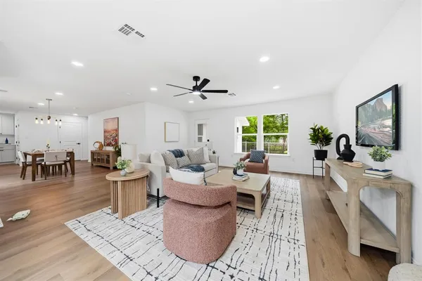 a living room with furniture a wooden floor and a large window