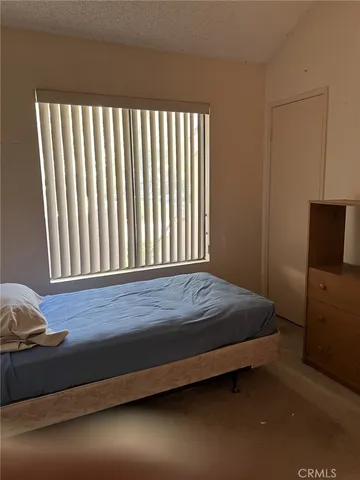 a bed sitting in a bedroom next to a window