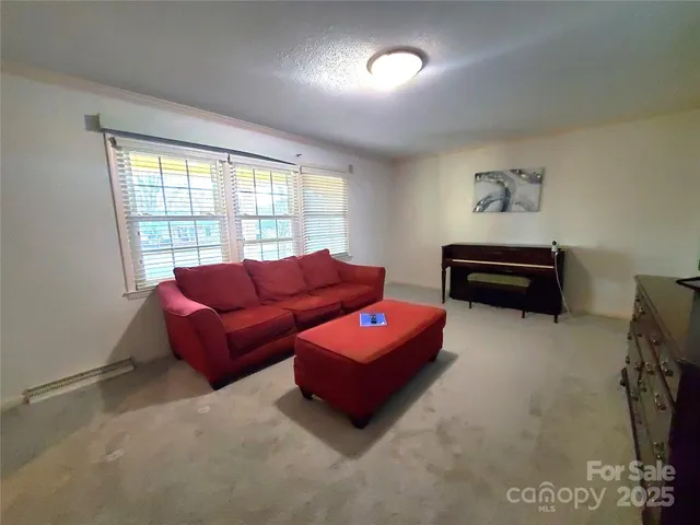 a living room with furniture a flat screen tv and a window