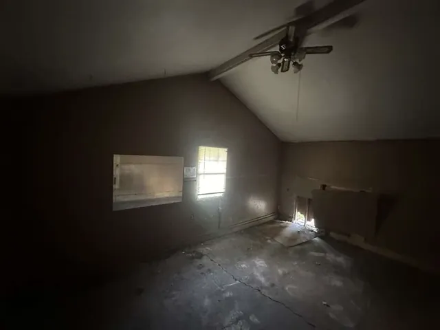 a view of empty room with ceiling fan and window