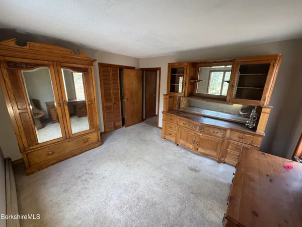 a view of an empty room with wooden floor a fireplace and a window