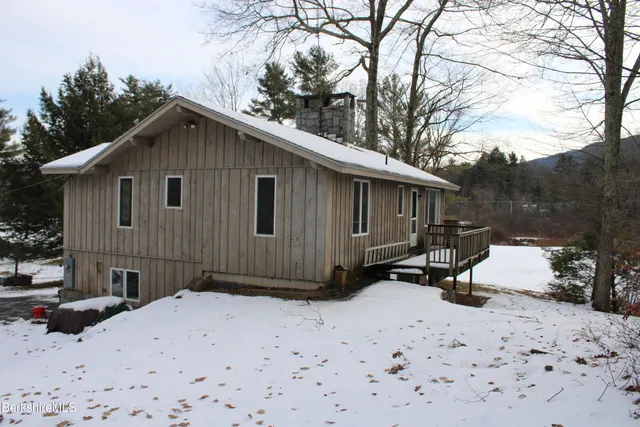a view of a house with a yard covered in snow