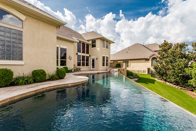 a view of house with swimming pool and outdoor seating