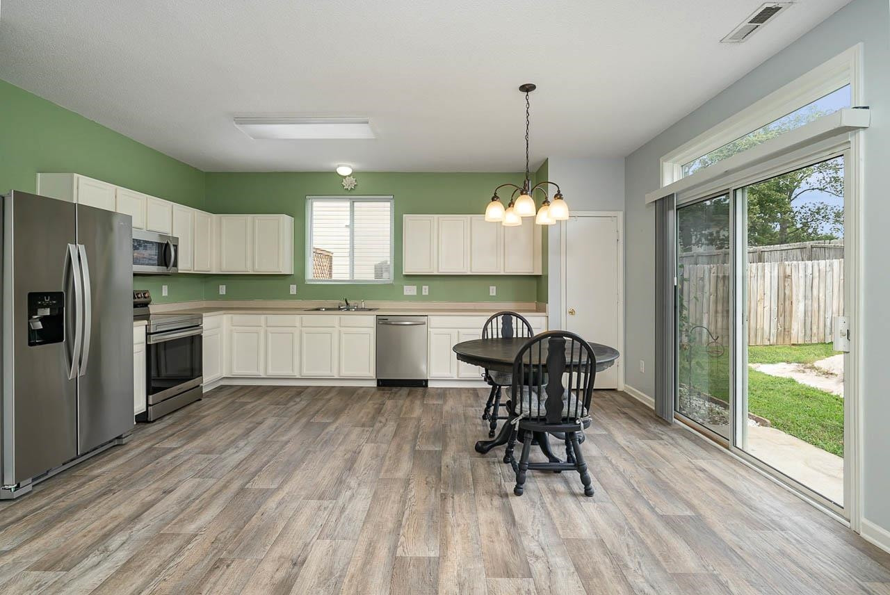 Ample storage in newly painted WHITE cabinets! Laminate floors, pantry and lots of space to add an island! Kitchen
