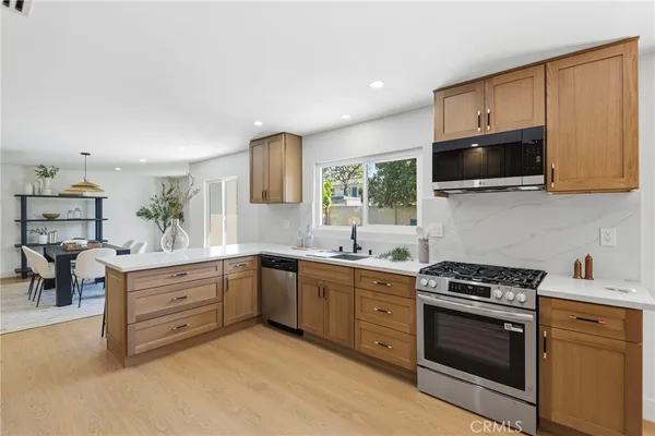a kitchen with cabinets stainless steel appliances and wooden floor