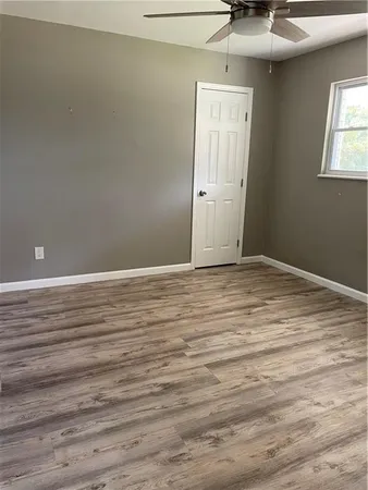 a view of empty room with window and wooden floor