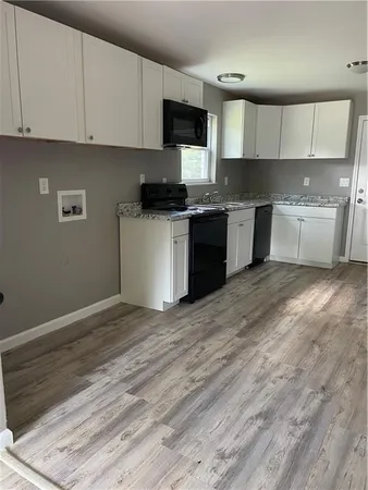 a kitchen with granite countertop a sink cabinets and stainless steel appliances