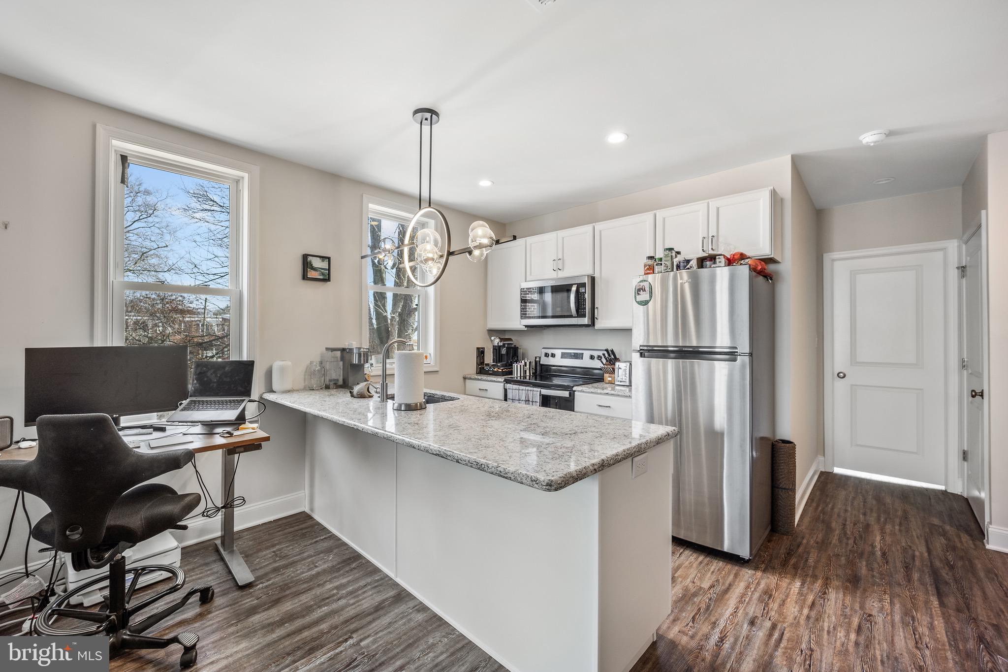 306 East Front Street Media, PA 19063 - Photo 4 of 10 a kitchen with stainless steel appliances a refrigerator a stove a sink dishwasher and white cabinets with wooden floor