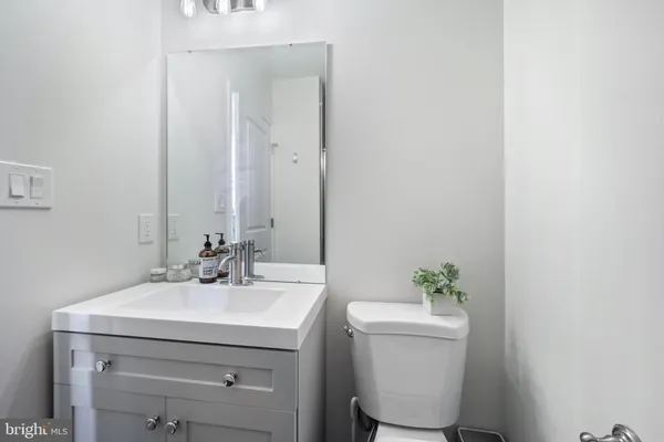 a bathroom with a sink a toilet and a mirror