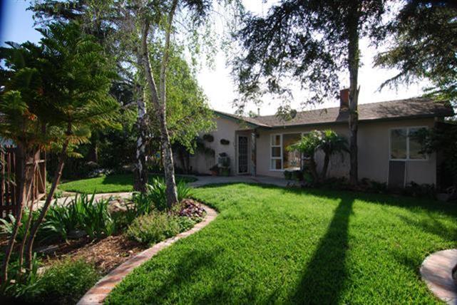 a view of a house with backyard and a tree