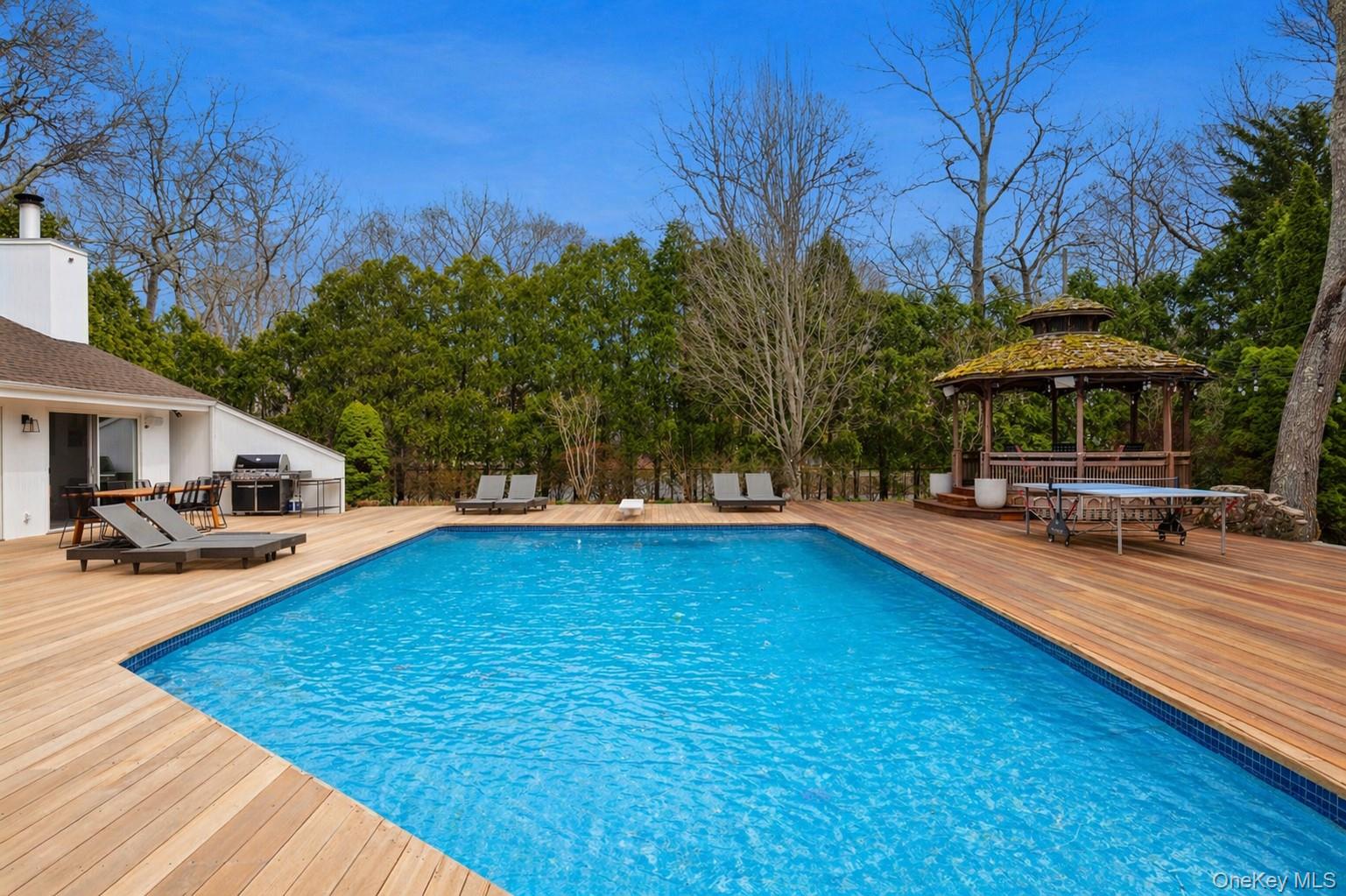 2 Acorn Path Quogue, NY 11959 - Photo 14 of 16 Expansive outdoor living area featuring a heated, gunite pool and a built-in gazebo